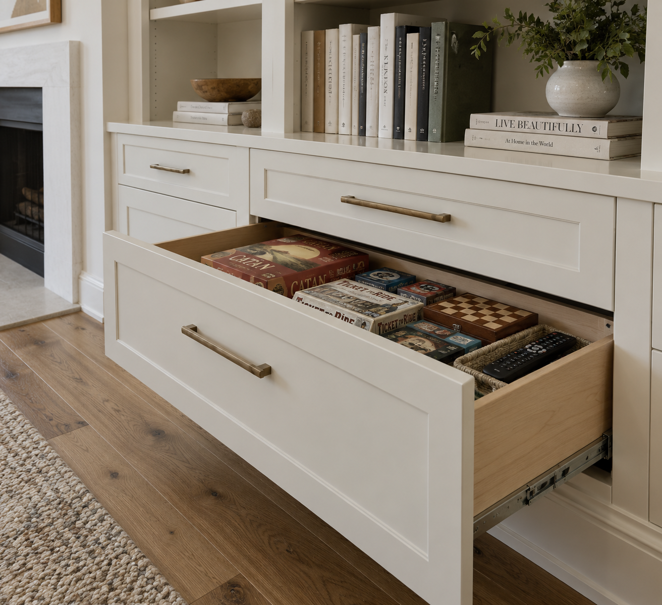 Open drawer in a painted living-room cabinet storing board games and remotes